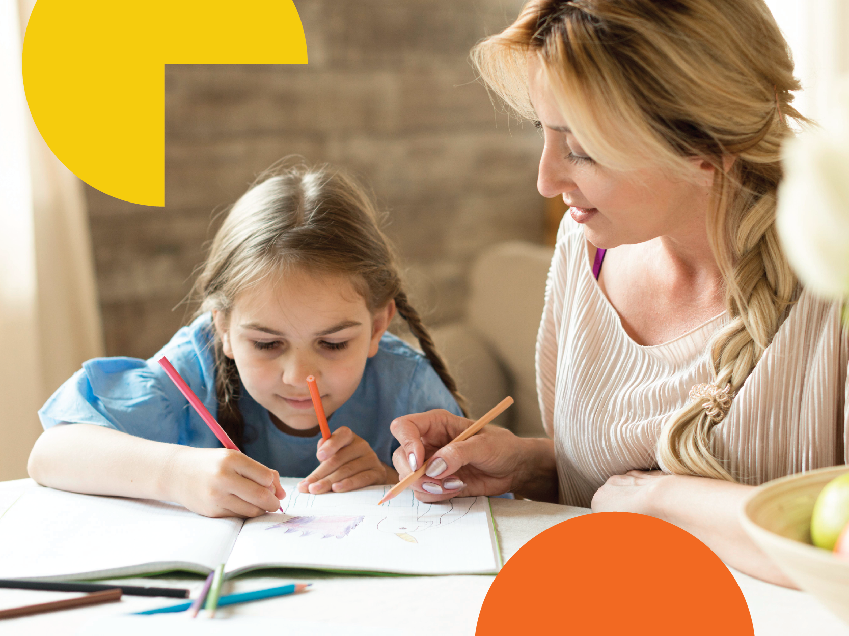 A woman with blonde hair and a braid helping a young girl with brown hair and braids with her drawing at a table, with colored pencils and an open notebook.