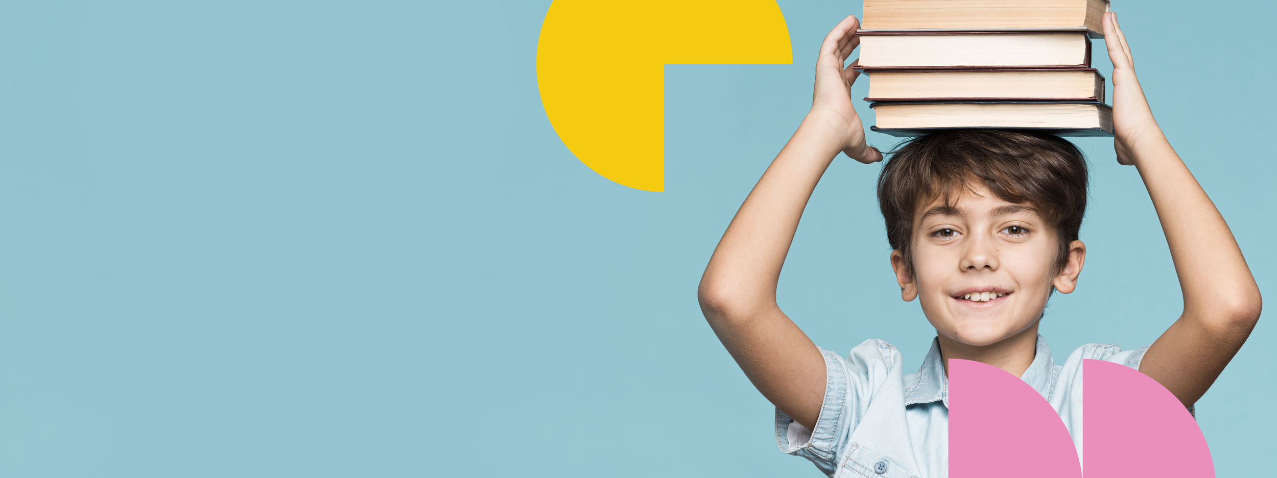 Young boy holding a stack of books on his head against a blue background with colorful geometric shapes.