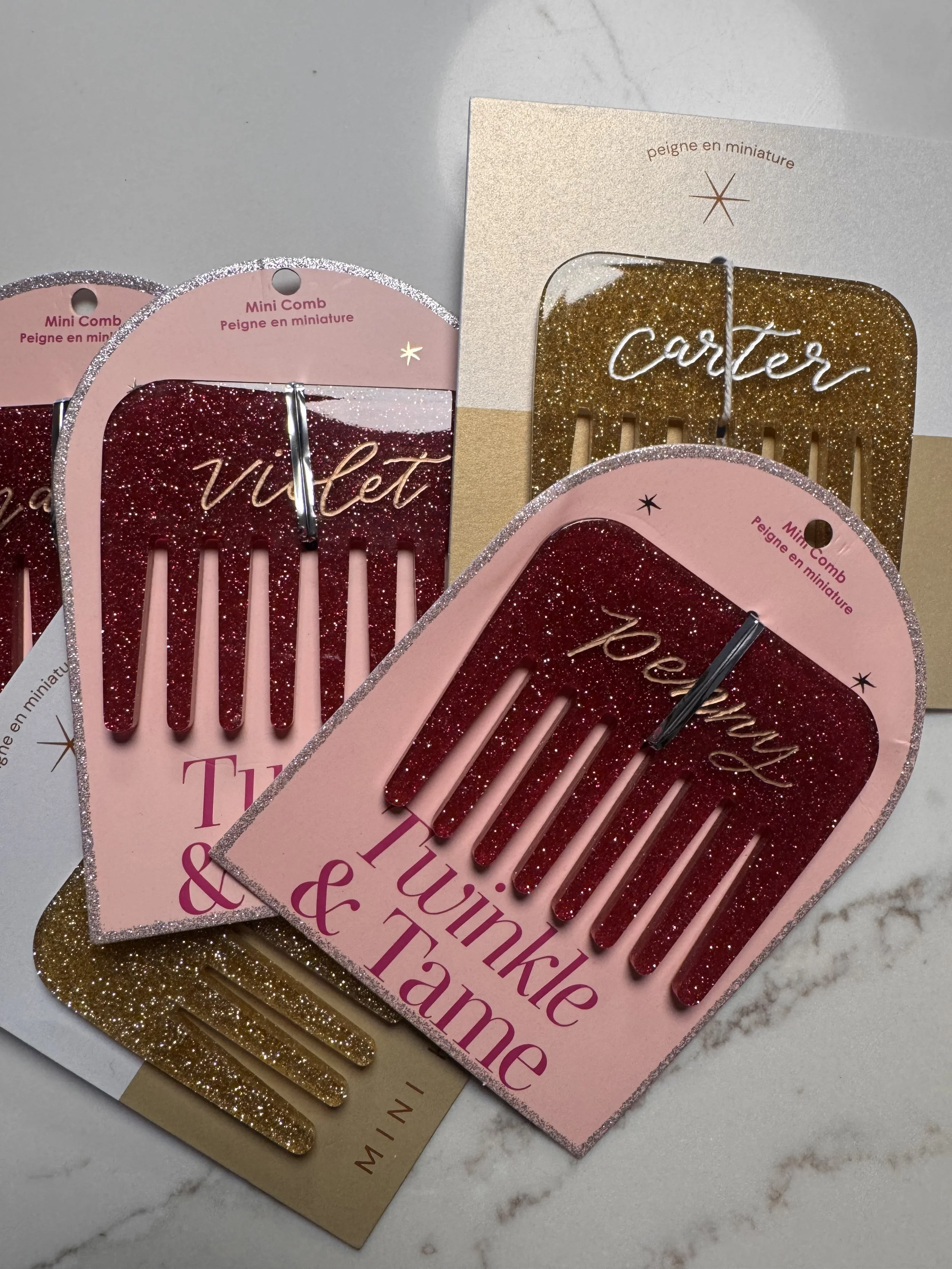 Set of decorative pink and gold hair clips with glitter, packaged on pink and gold cardboard backing, text on packaging reads "Mini Comb" and "lifter".