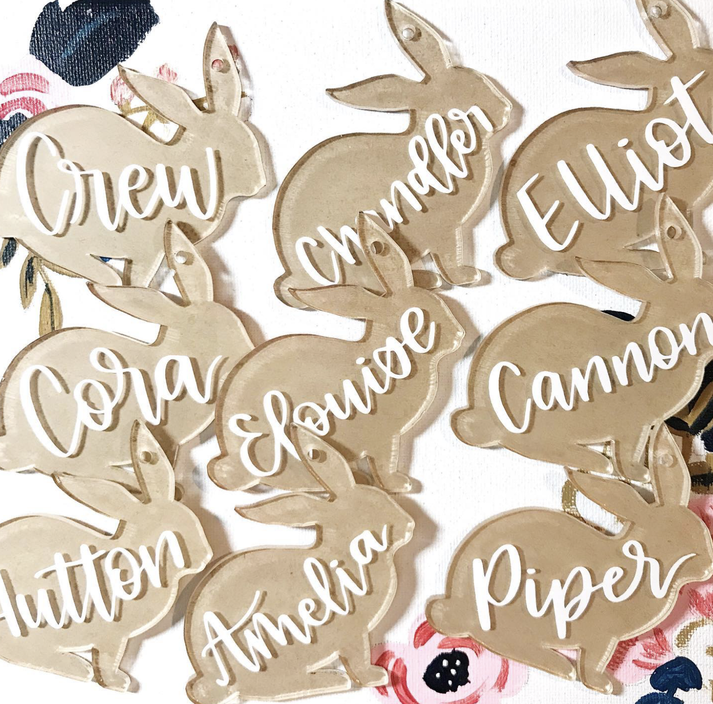 Multiple beige bunny-shaped cutouts with names written in white cursive, including 'Craw,' 'Cinnamon,' 'Evelyn,' 'Autumn,' 'Amber,' and 'Piper'.