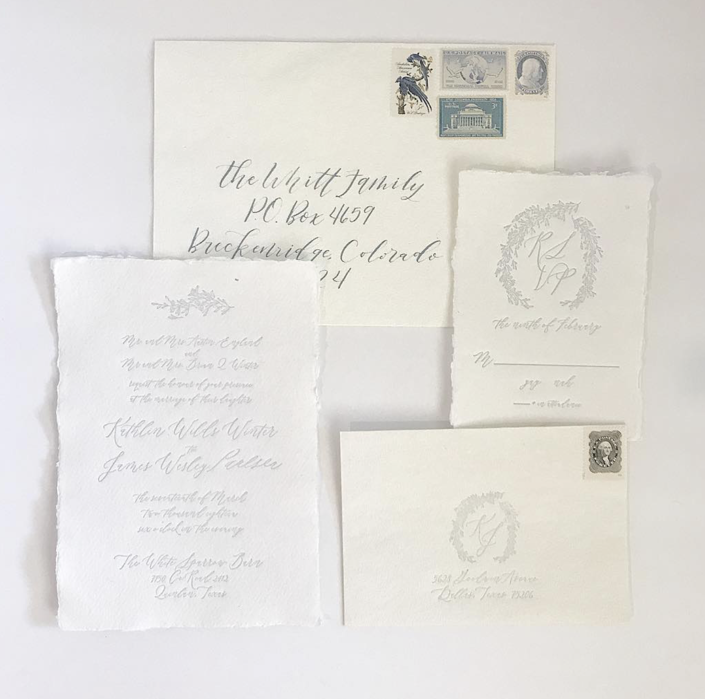 Elegant white stationery with handwritten addresses, some featuring decorative borders, a pile of vintage postage stamps in the top right corner, and faint embossed initials.