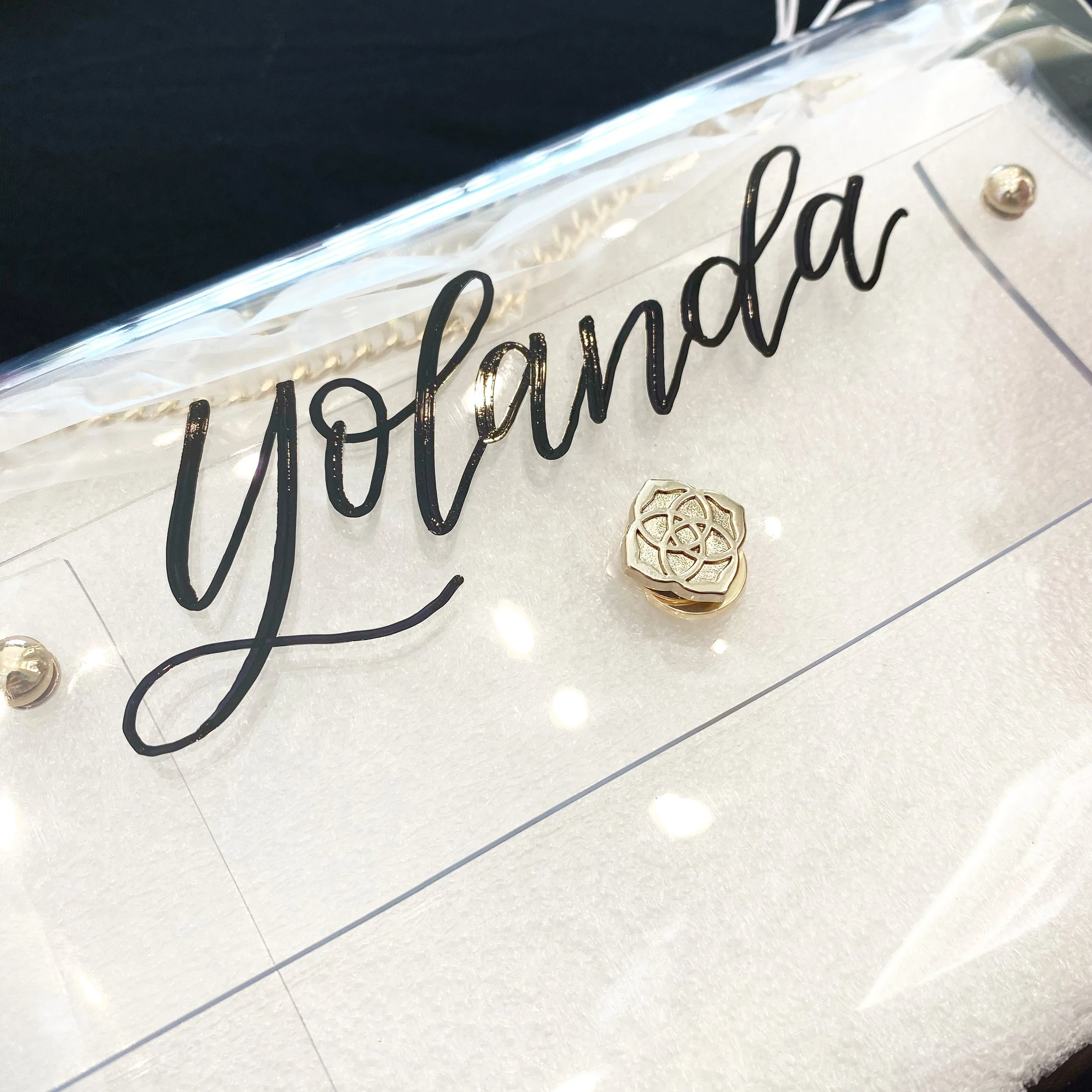 Close-up of a decorative sign with the word 'hope' written in black cursive lettering, gold-colored ornaments, and white string lights on a white textured surface.