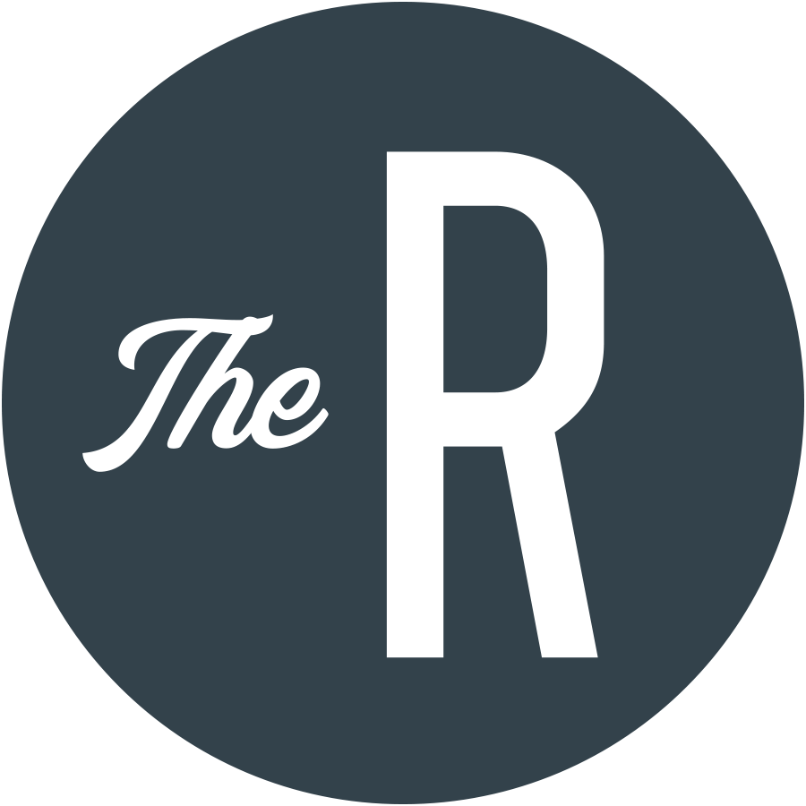 A circular logo with a dark background featuring the words "The" in a cursive font and a large capital letter "R" in a bold font.