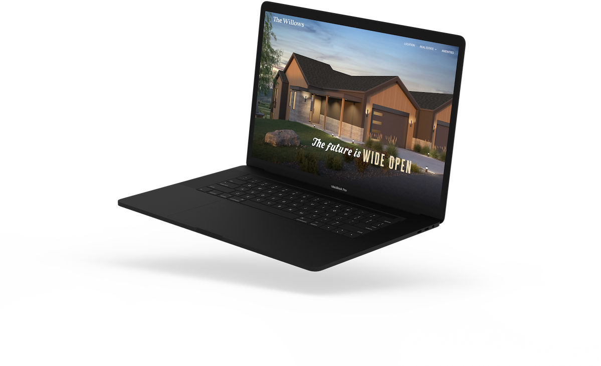 A black laptop displaying a website for a real estate property called "The Willows," showing an image of a modern house with the text "The future is WIDE OPEN."