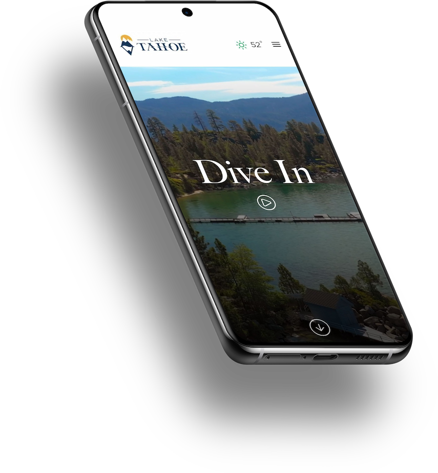 Smartphone displaying a website for Lake Tahoe with a scenic view of the lake, trees, and mountains, and text that reads 'Dive In'.