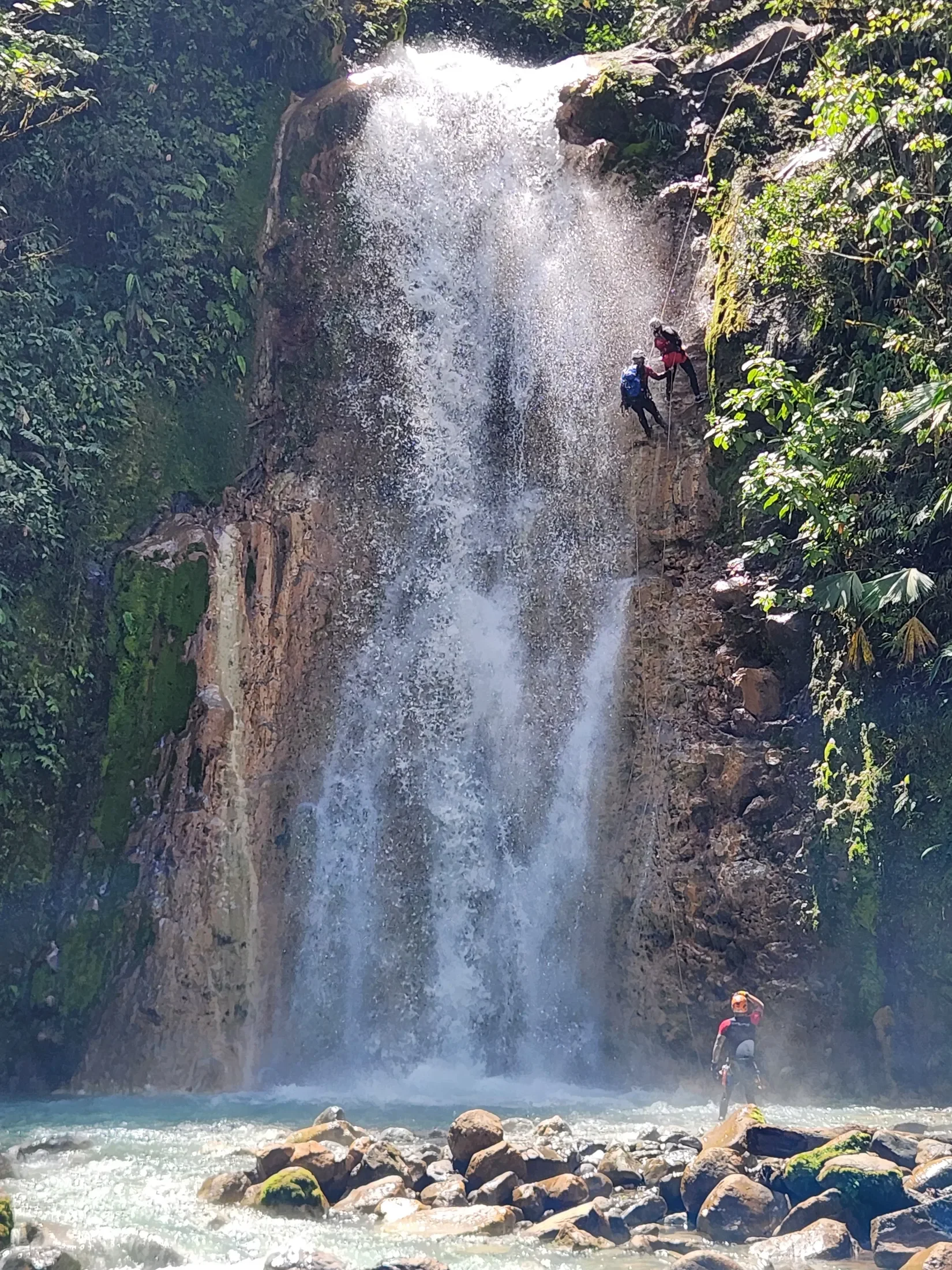 Women's retreat group rappelling down a waterfall cliff during a Costa Rica Vacation