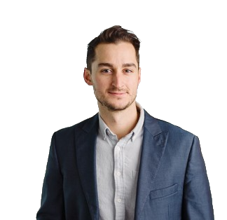 A young man wearing a suit jacket and a light-colored shirt, smiling at the camera against a white background.
