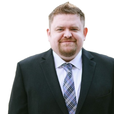 Portrait of a man in a dark suit and plaid tie smiling against a plain white background.