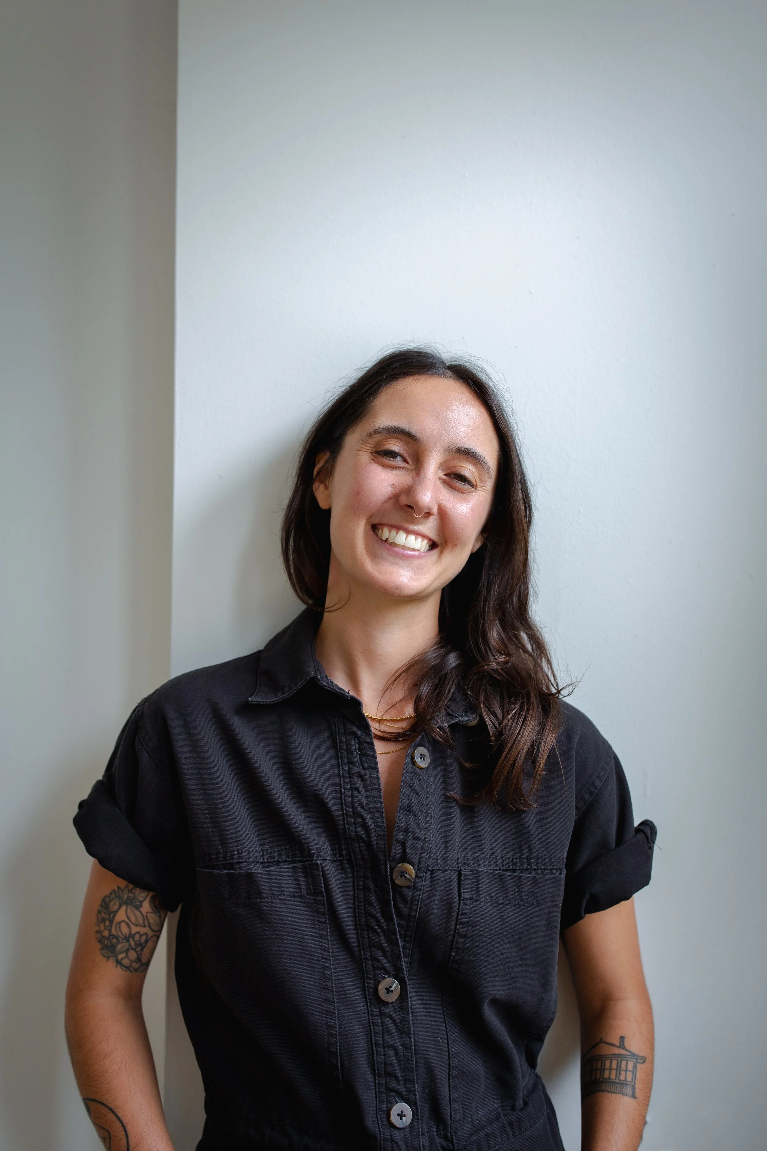 Kate leans against a wall smiling