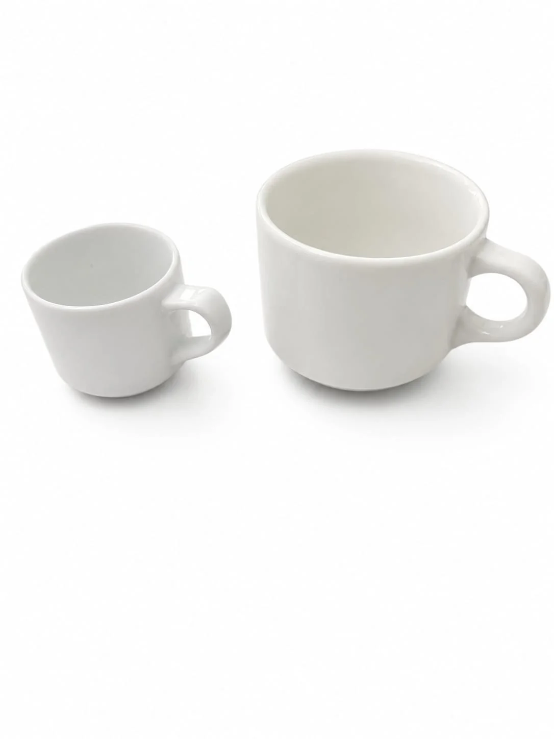 Deux tasses blanches, une petite et une grande, sur fond blanc.