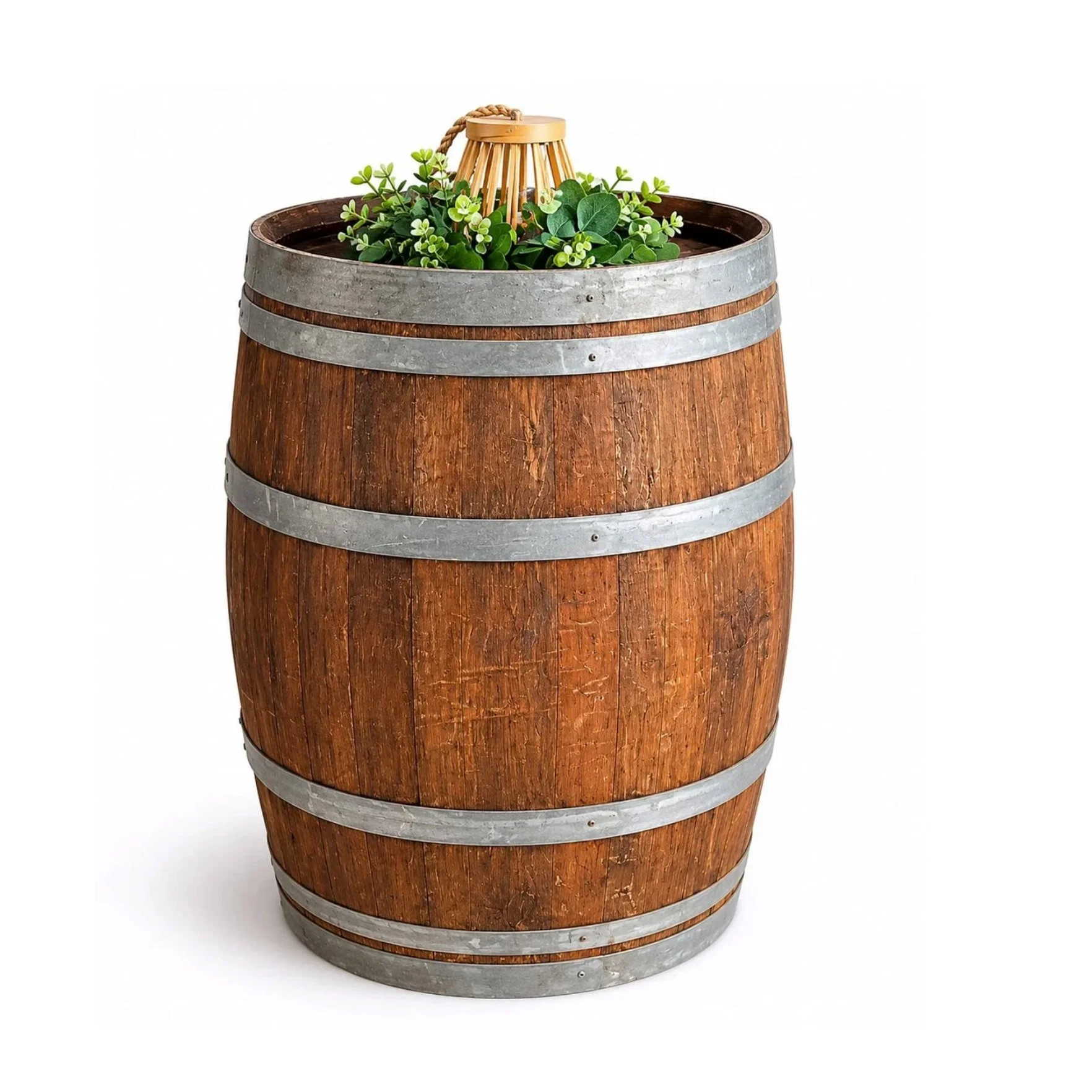 Un baril en bois converti en jardinière avec des plantes vertes et un petit objet en bois en forme de cage ou d'abri pour plante.
