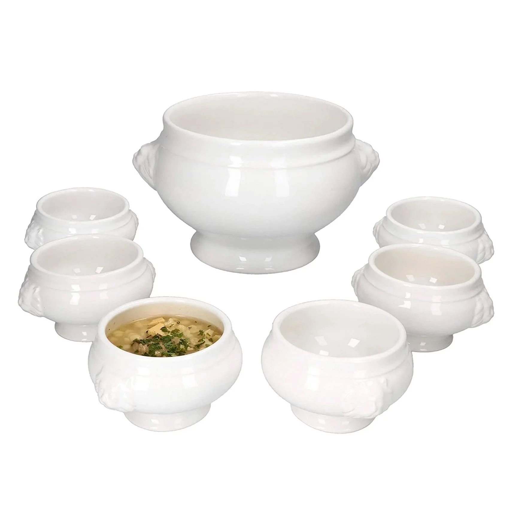 Assiette de soupe avec herbes, entourée de plusieurs bols blancs vides sur fond blanc.