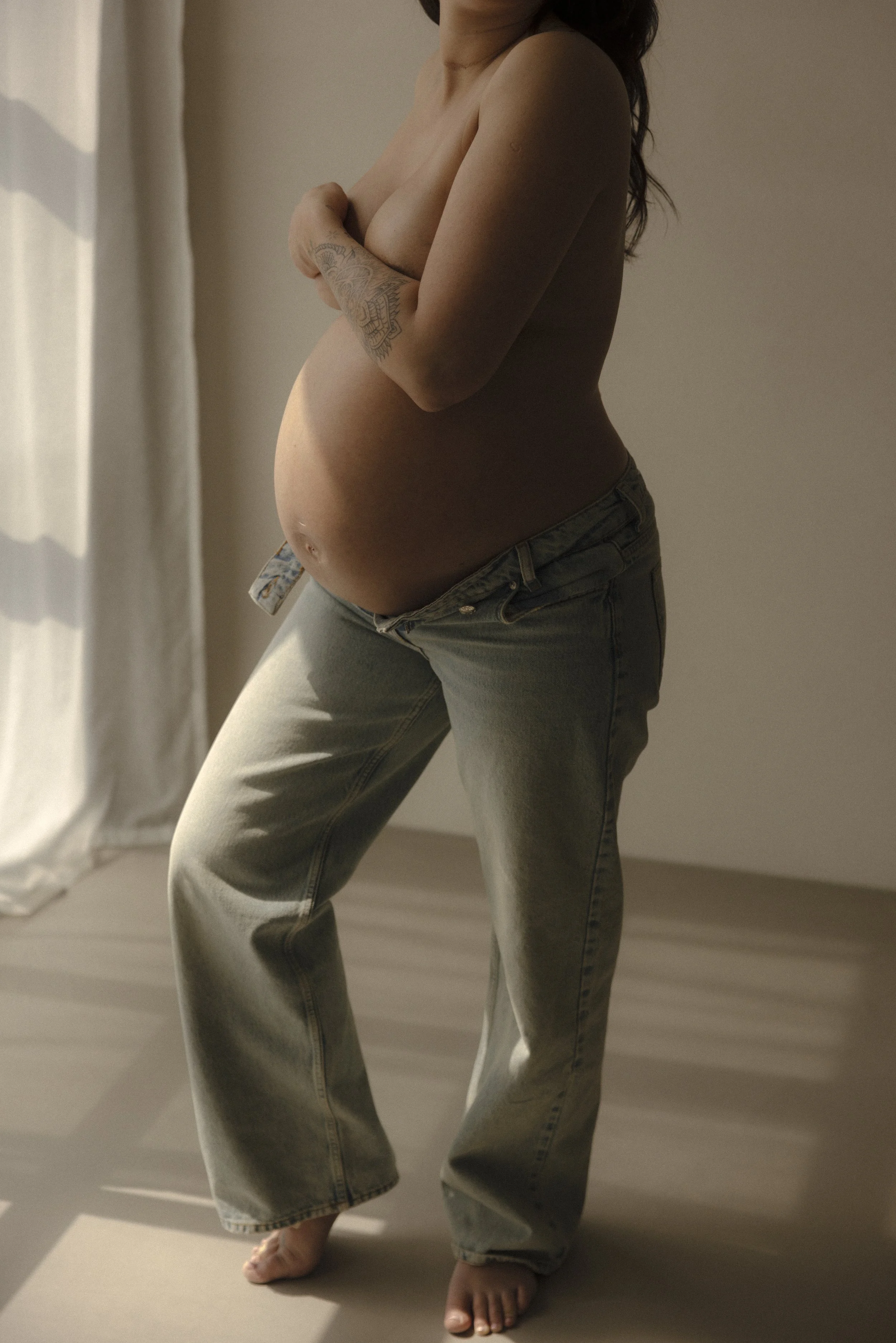 Eine schwangere Frau zeigt ihren Bauch bei ihrem Schwangerschaftshooting in Luzern.