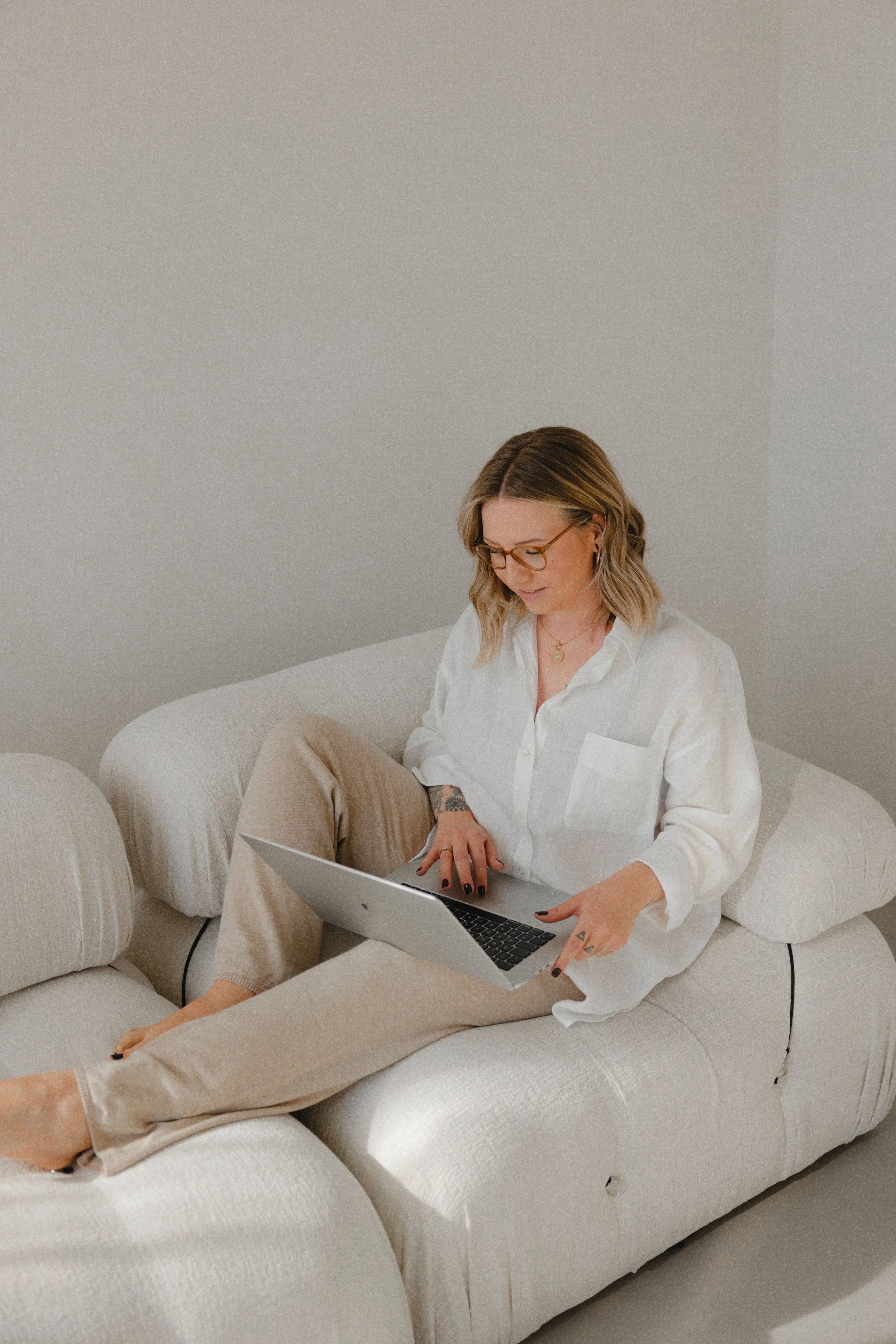 Diese Frau sitzt auf dem Sofa im vollmöblierten Fotostudio in Luzern. Personal Branding Fotografie in Zürich und Luzern.
