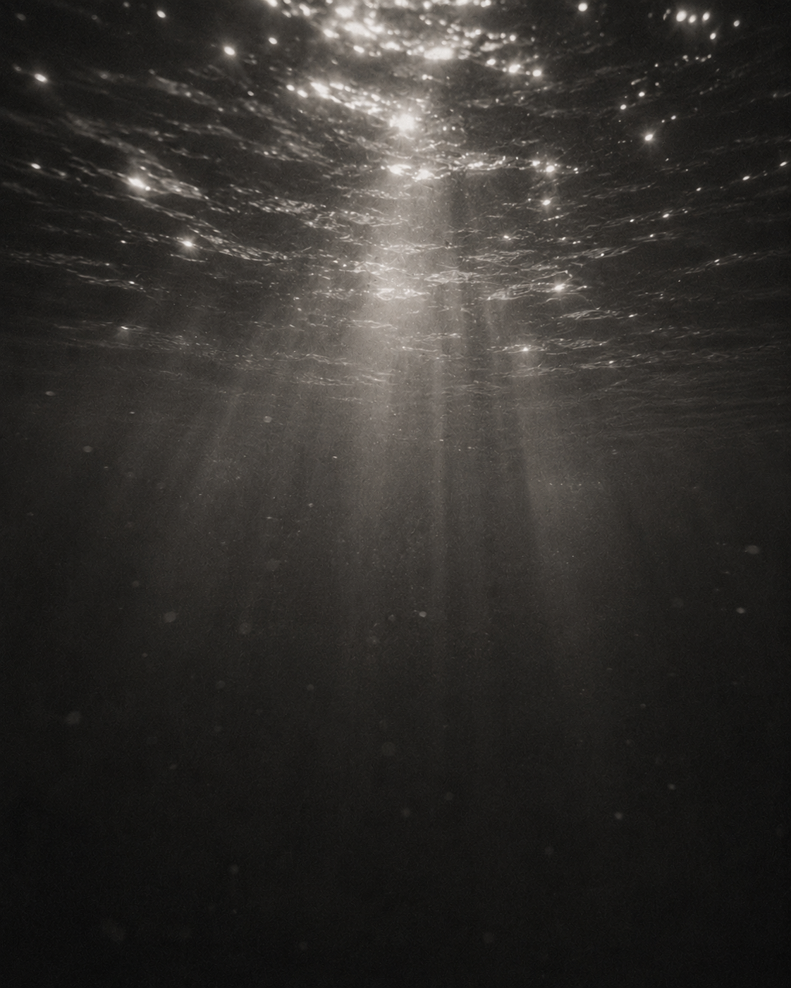 Underwater view with sunlight rays piercing through the water surface.