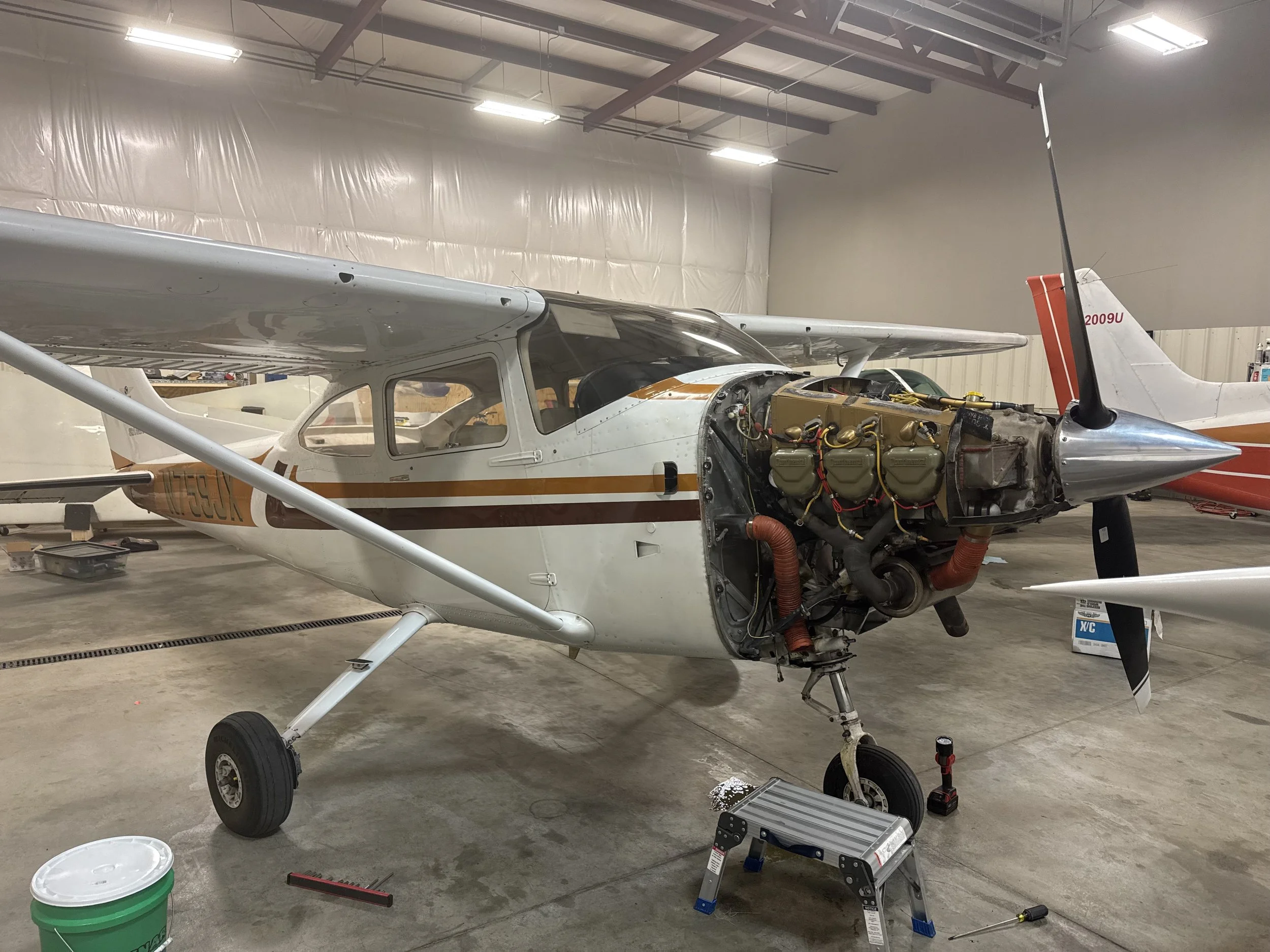 Inside a hangar with an aircraft undergoing maintenance or repair. Cessna 182.
