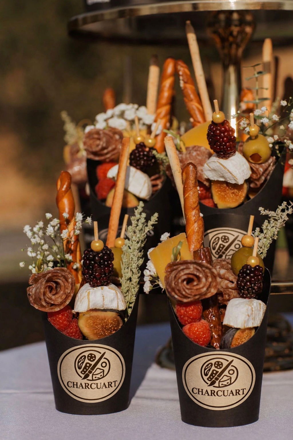 Charcuart branded grazing cones filled with charcuterie, brie, berries, figs, breadsticks and salami roses — perfect for events and parties.
