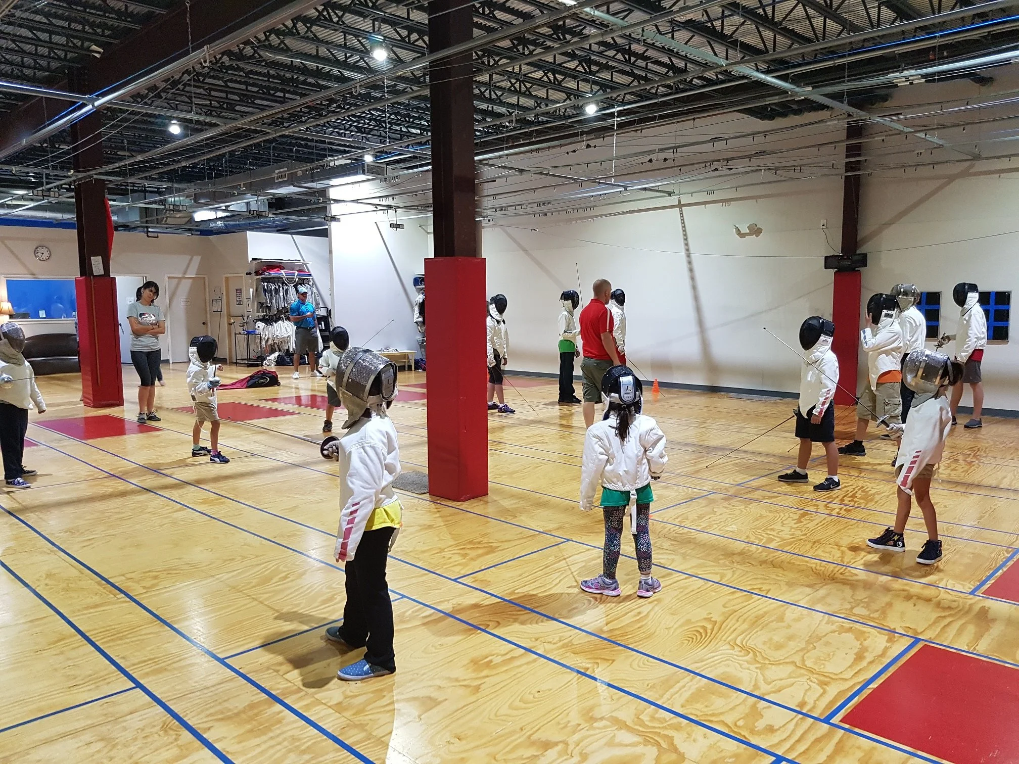 A group of young fencers waits for an opportunity to fence