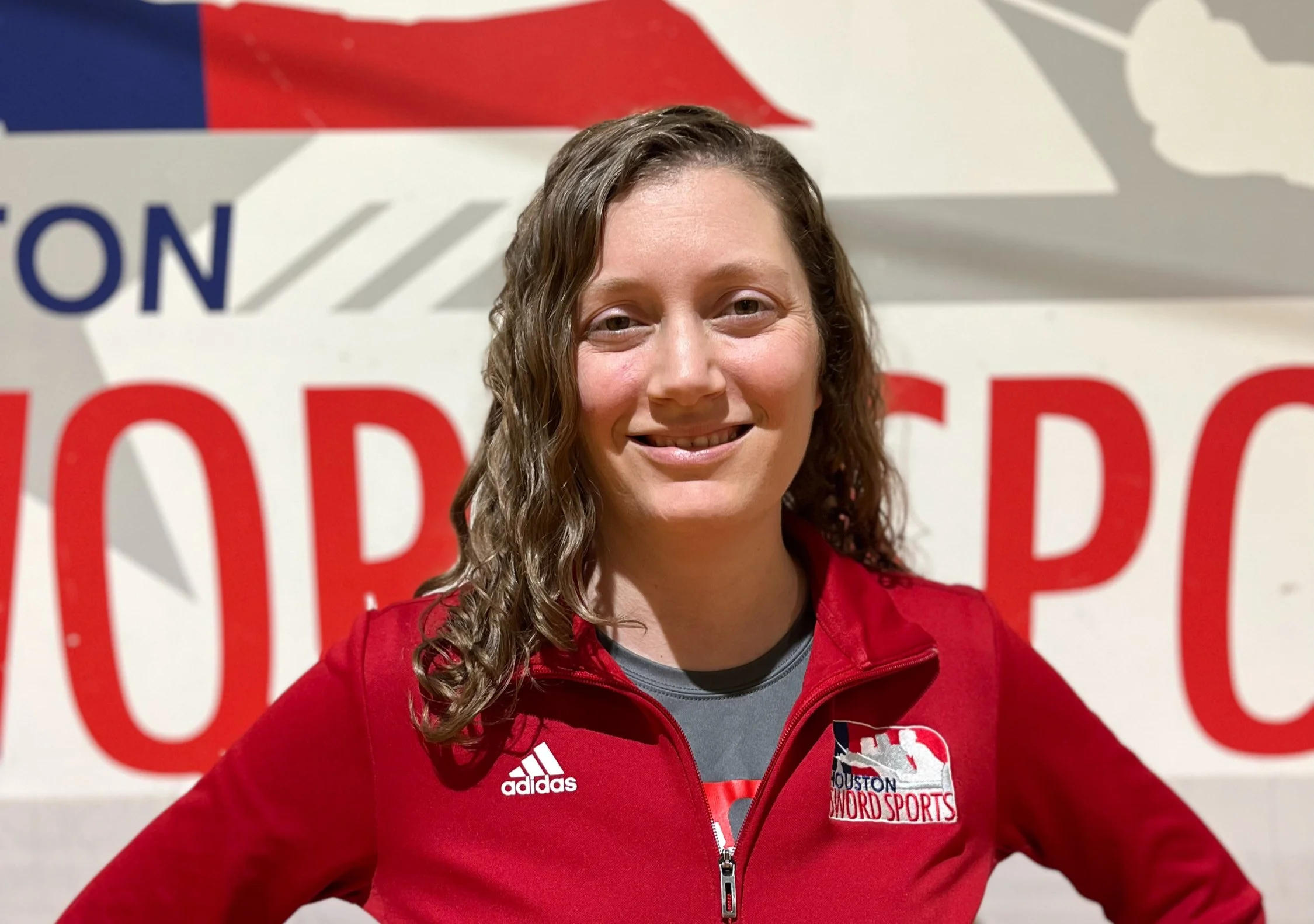 Liz Mayerich smiling in front of the HSS logo