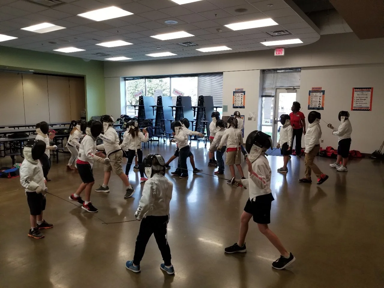 Fencers in the cafeteria at Herod Elementary practice bouting with each other