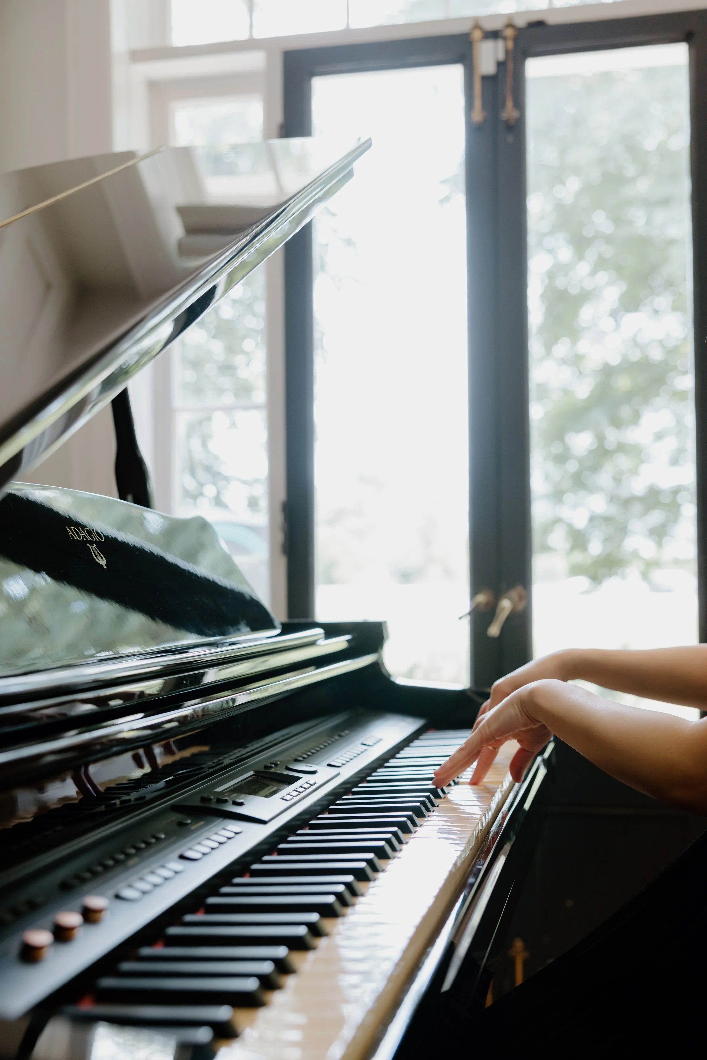 Close-up of a pianist's hands playing a grand piano.