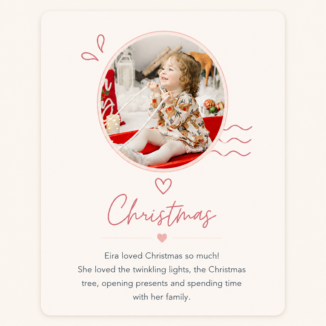 A young girl sitting on a red sled, smiling, with Christmas decorations and fairy lights in the background.