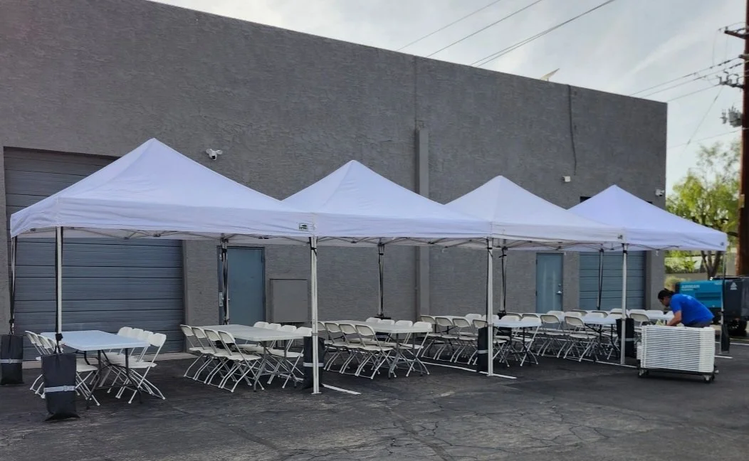 White canopy tent rentals with tables and chairs set up for an outdoor event in Phoenix, Arizona
