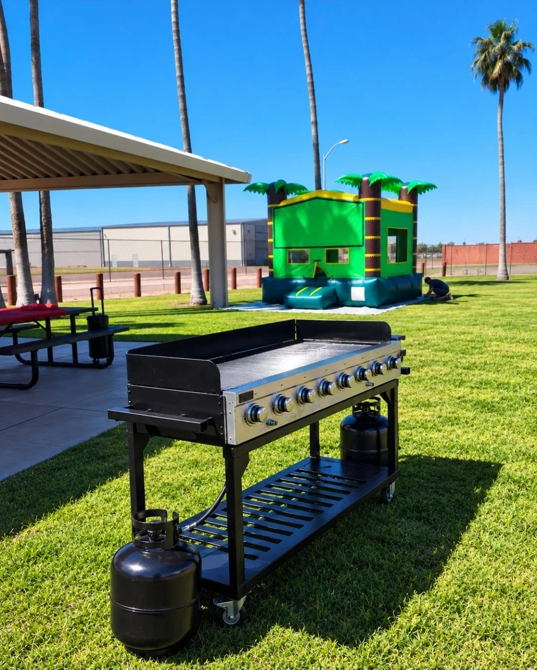 Large stainless steel propane gas grill rental with 8 control knobs on a wheeled stand for parties and events in Phoenix, Arizona.
