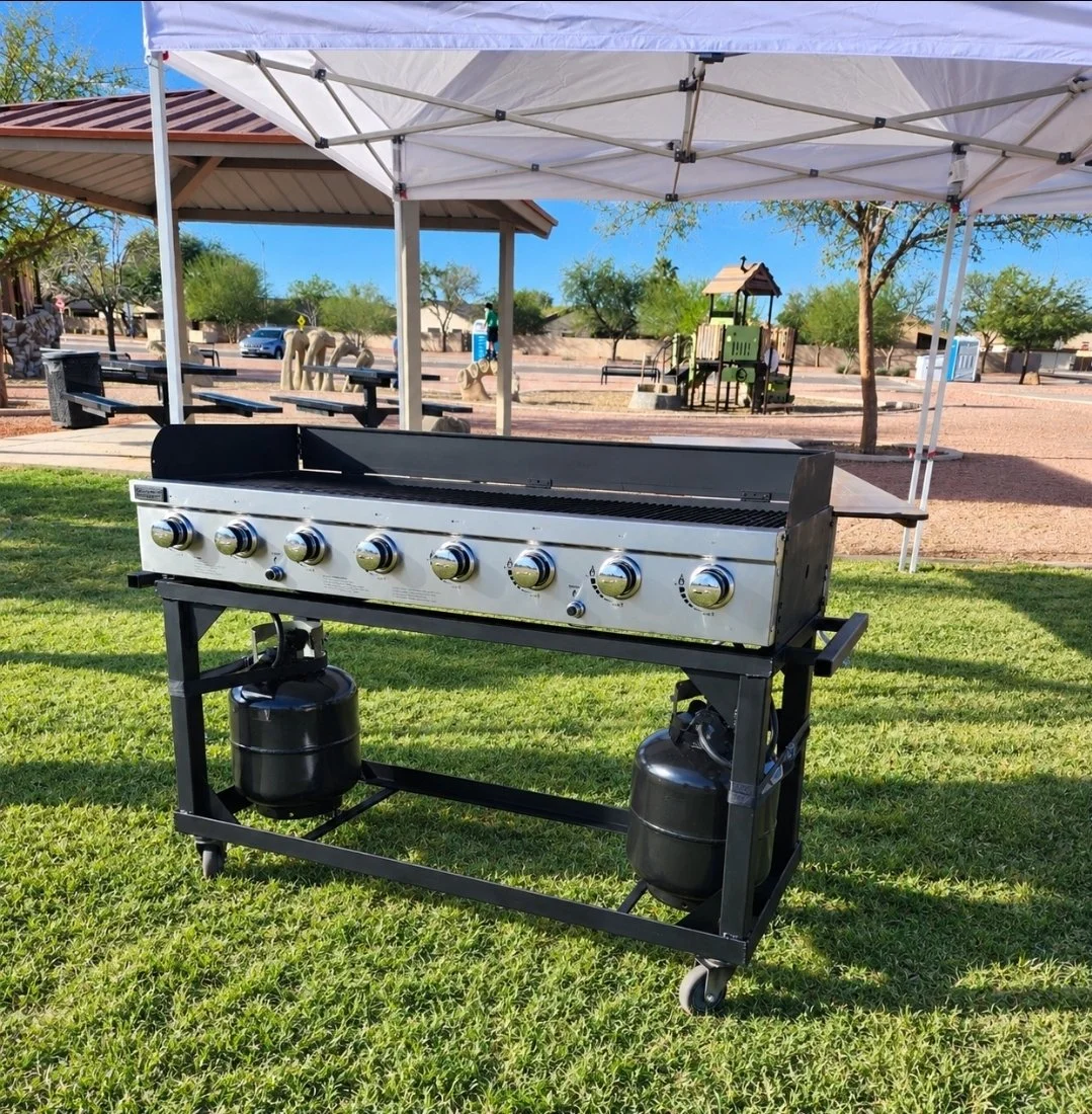 Outdoor propane gas grill rental set up under a white canopy tent for an event in Phoenix, Arizona.