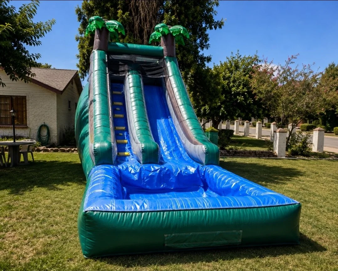 Inflatable water slide in a backyard with trees and a house in the background.