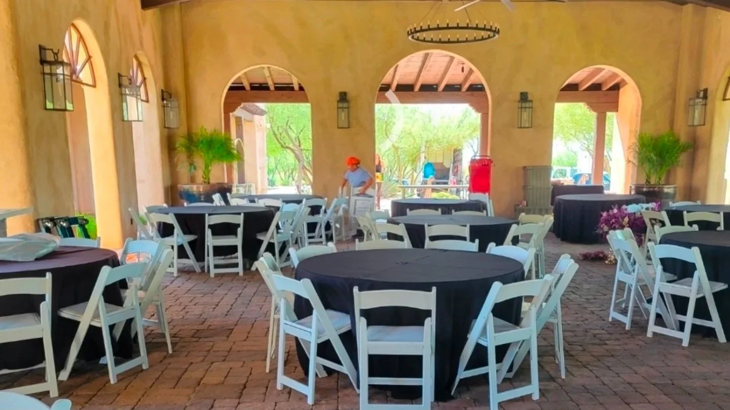 Round table and white folding chair rentals set up for an indoor event in Phoenix, Arizona.