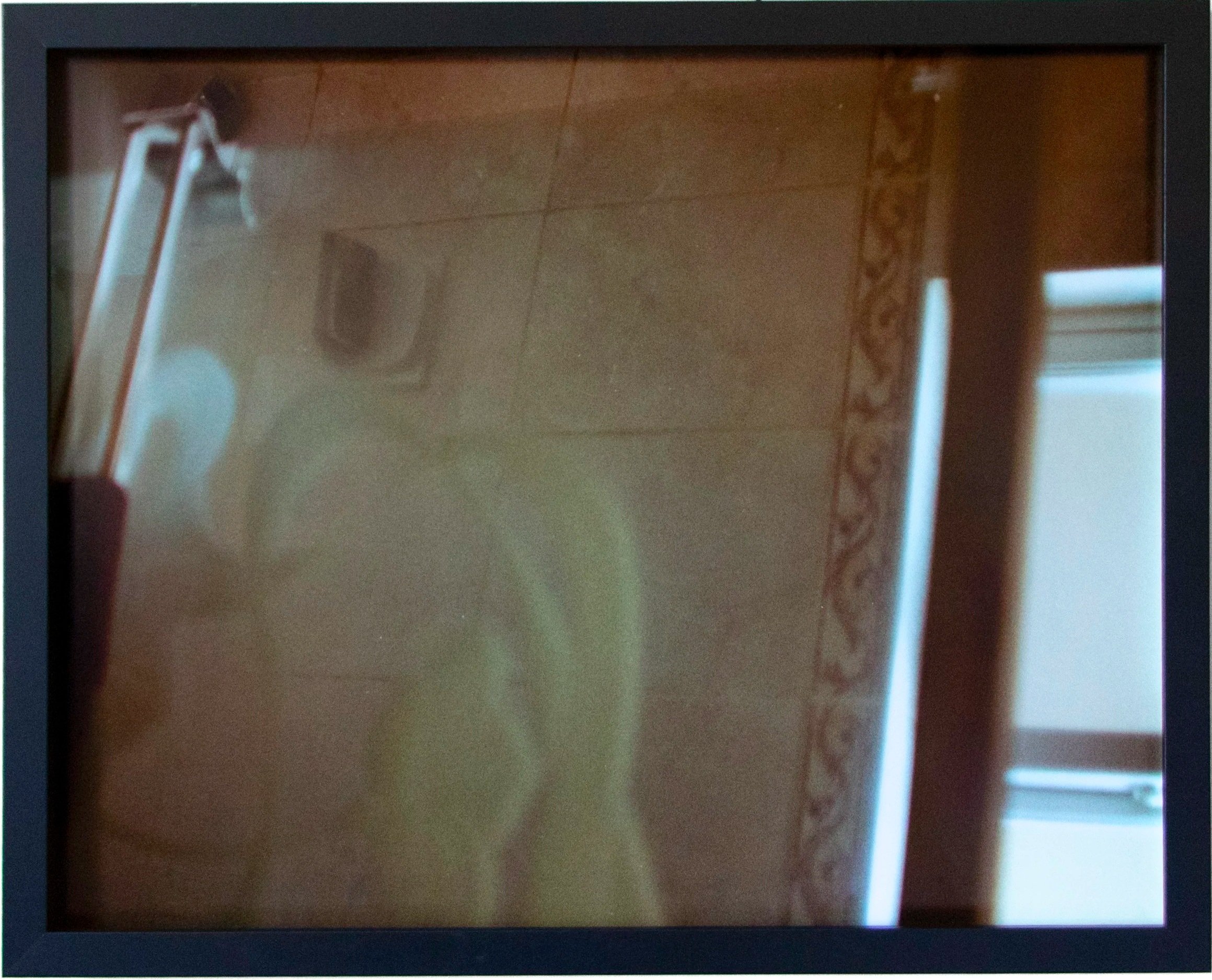 An electronic device with a screen displaying a mirror image of a bathroom with a sink, mirror, and a curtain.