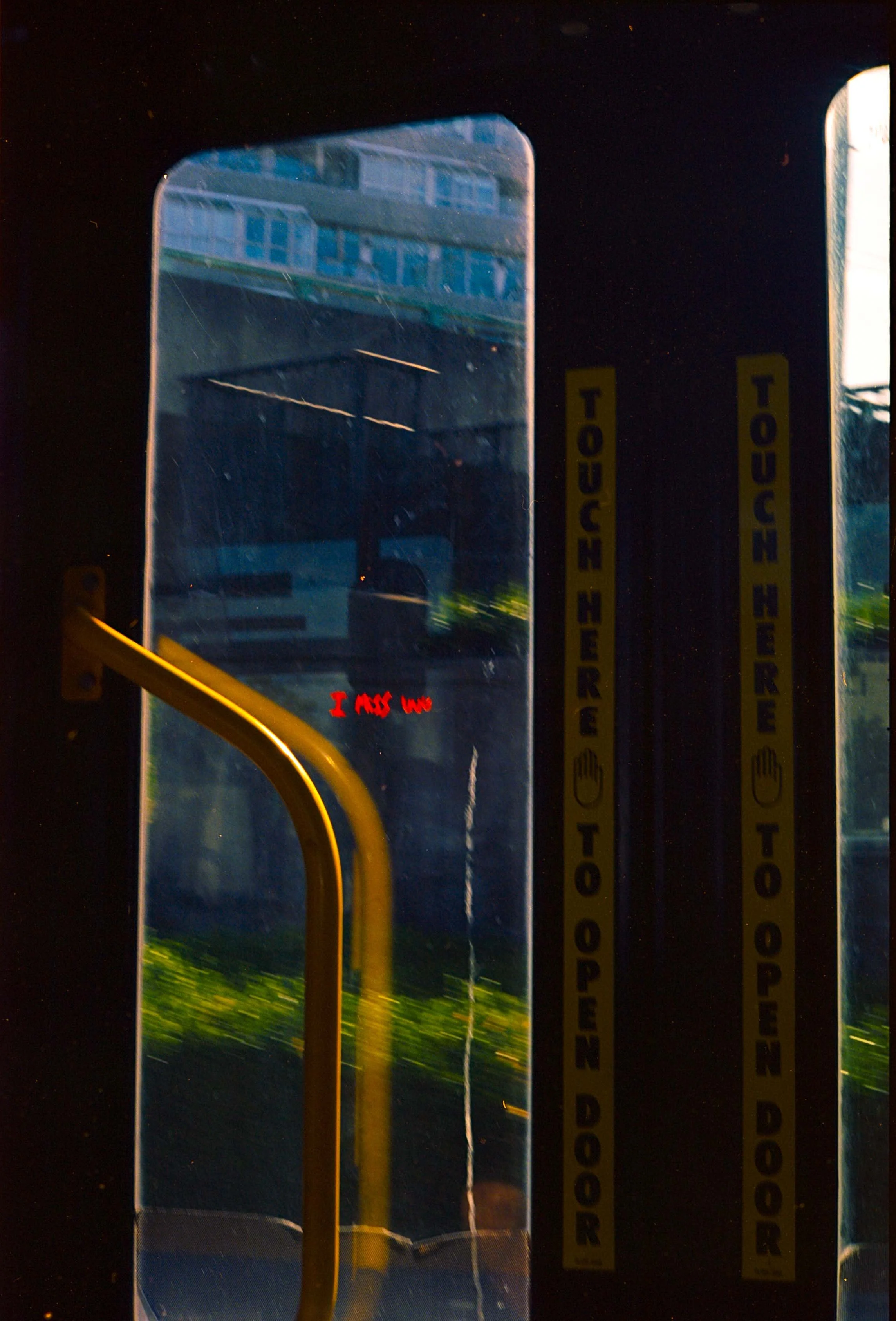 handwritten red text of a bus door that reads 'i miss you'