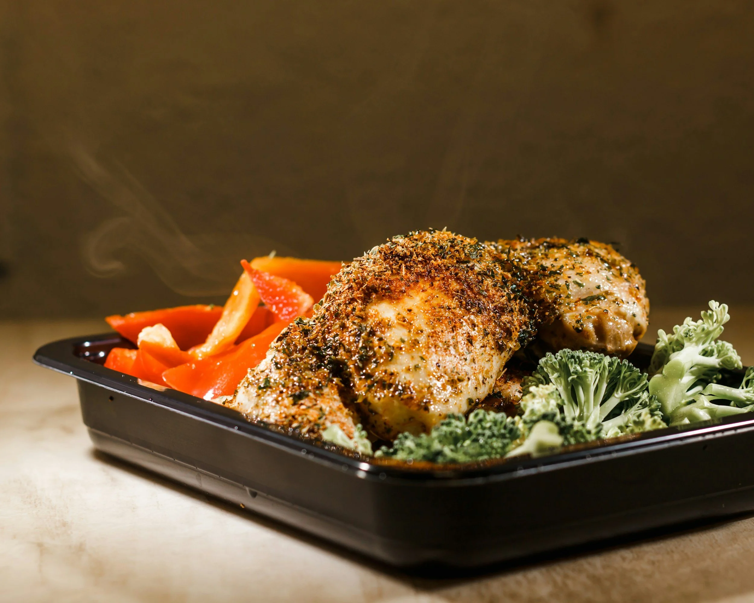 Tray with chicken, broccoli, and carrots served as a healthy meal.