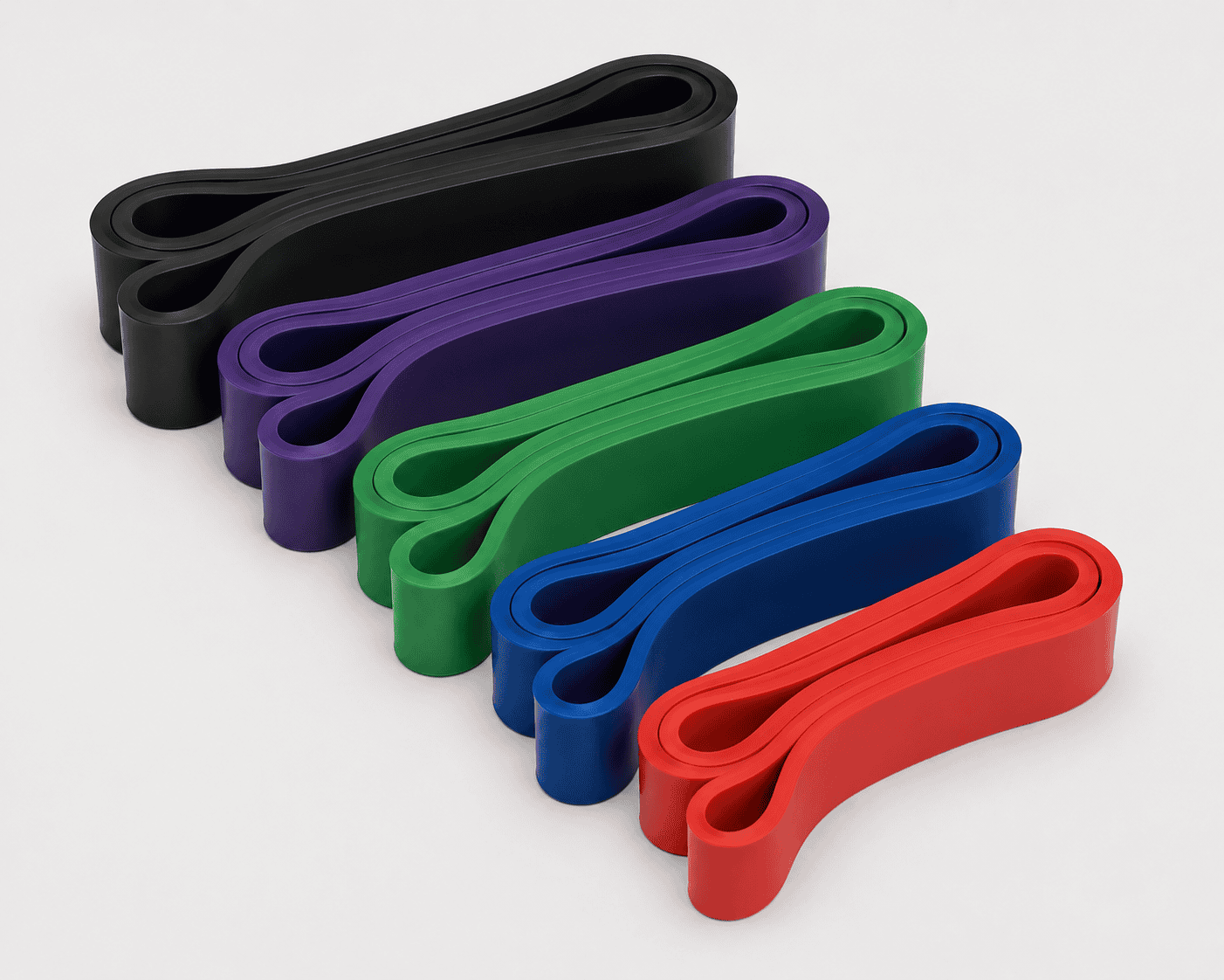 Five resistance exercise bands in black, purple, green, blue, and red, laid out on a white surface.