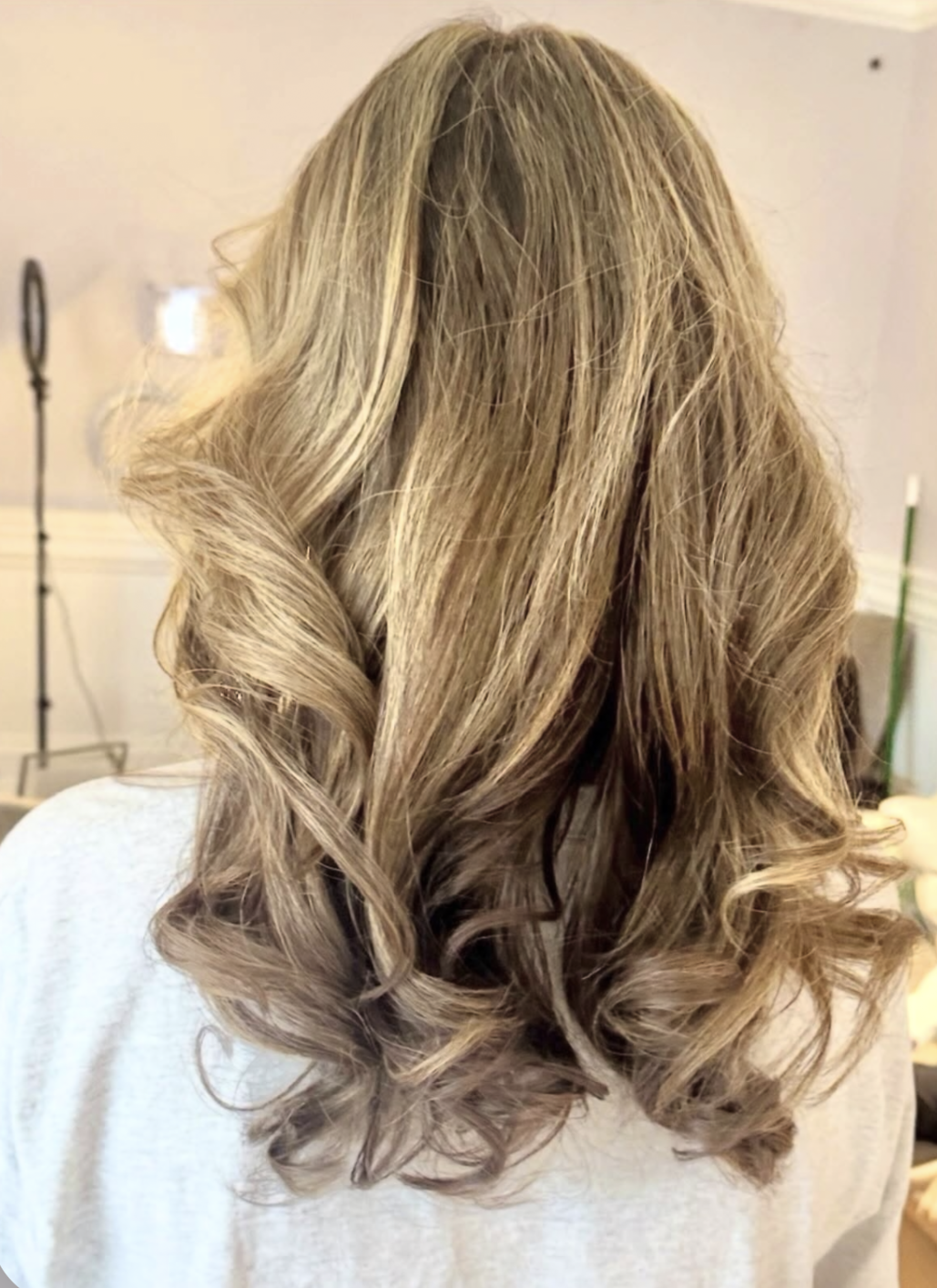 Woman with long, blonde, styled, curled hair.