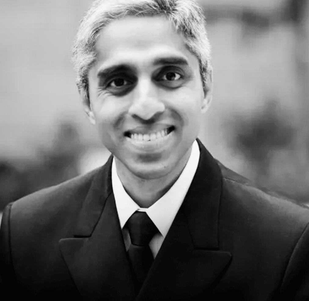 Black and white portrait of a smiling Vivek Murthy in a suit and tie.