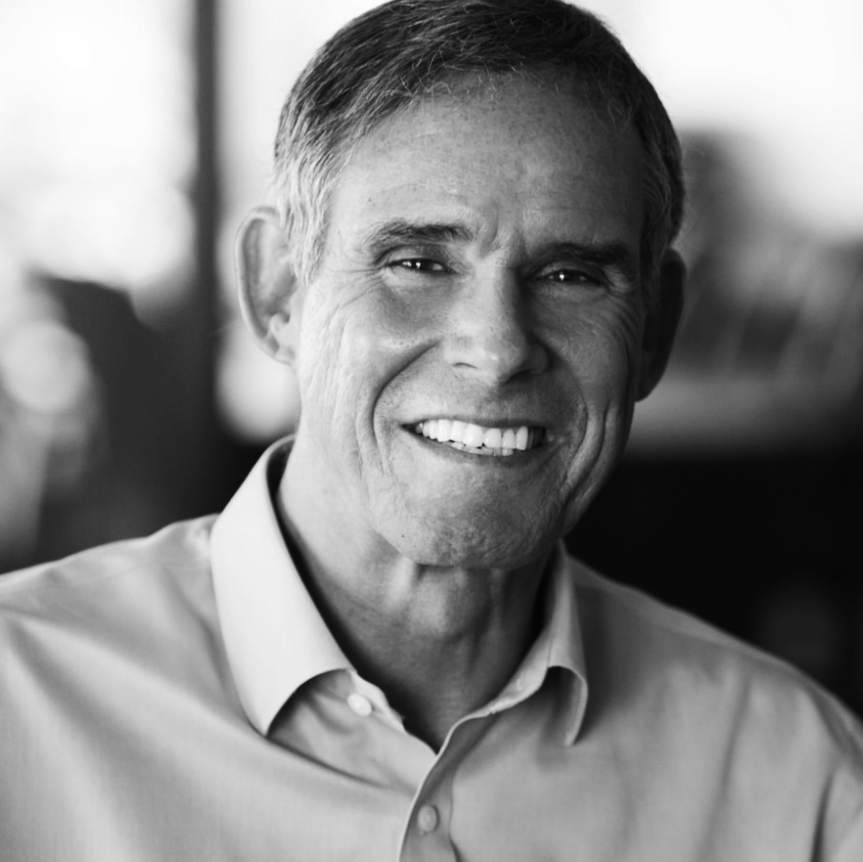 Black and white photo of Dr. Eric Topol, smiling, wearing a collared shirt.