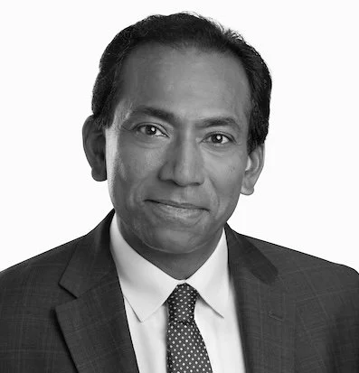 Black and white professional portrait of Vijay V. Vaitheeswaran in a suit and tie.