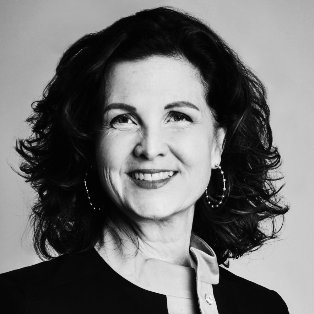 Black and white portrait of Kathy Baughman McLeod, wearing earrings and a collared shirt.