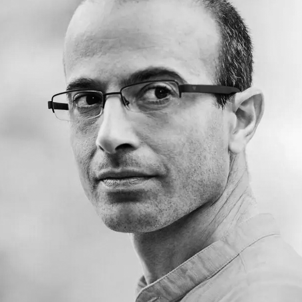 Black and white close-up portrait of Yuval Harari, and a slight smile, looking at the camera.