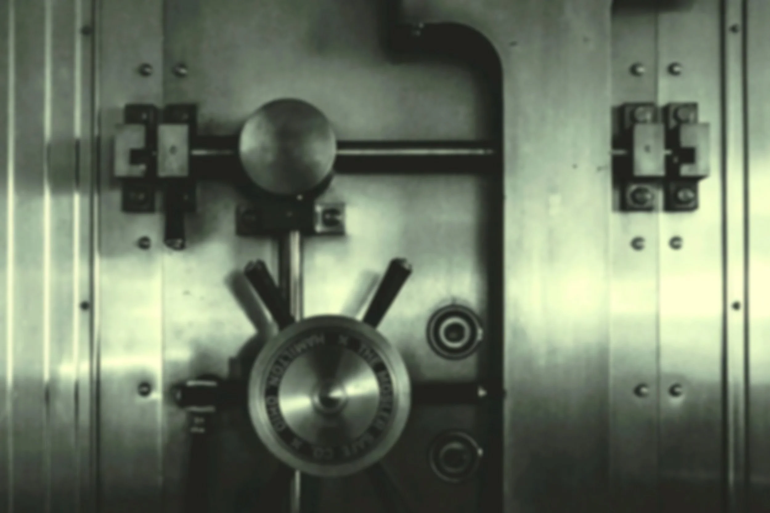 Close-up of a metallic combination lock safe door with the dial and rotating wheel. Representative of security and safety.