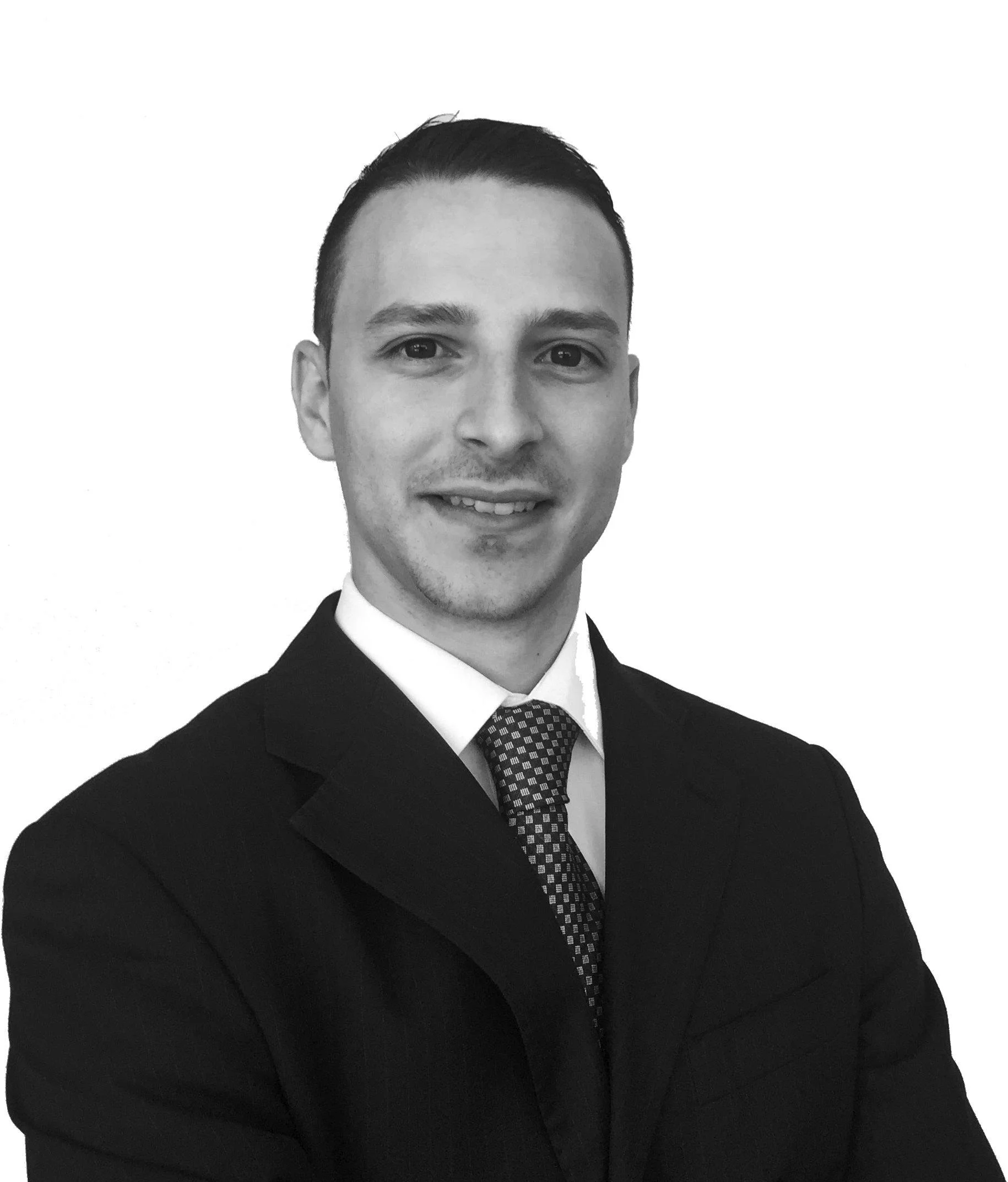 A Black and white portrait of a man in formal attire, wearing a suit and tie, smiling with a white background. A professional profile.
