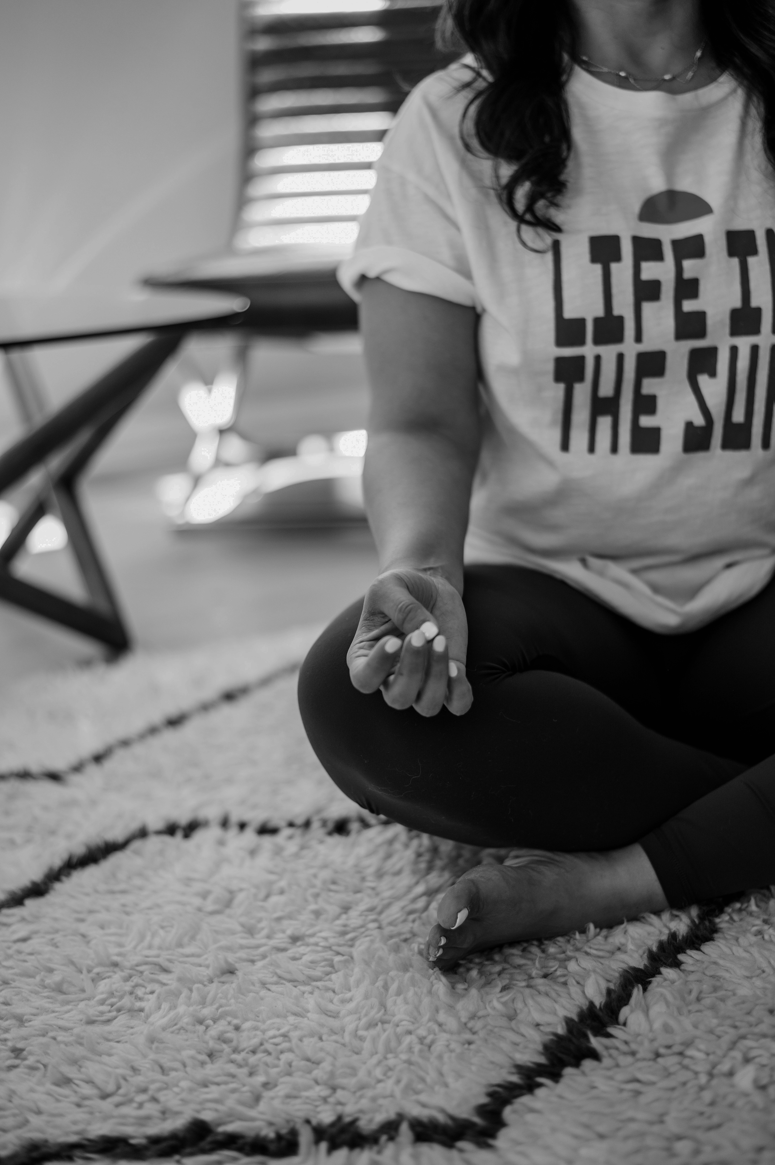 Black-and-white portrait of Asha seated in meditation