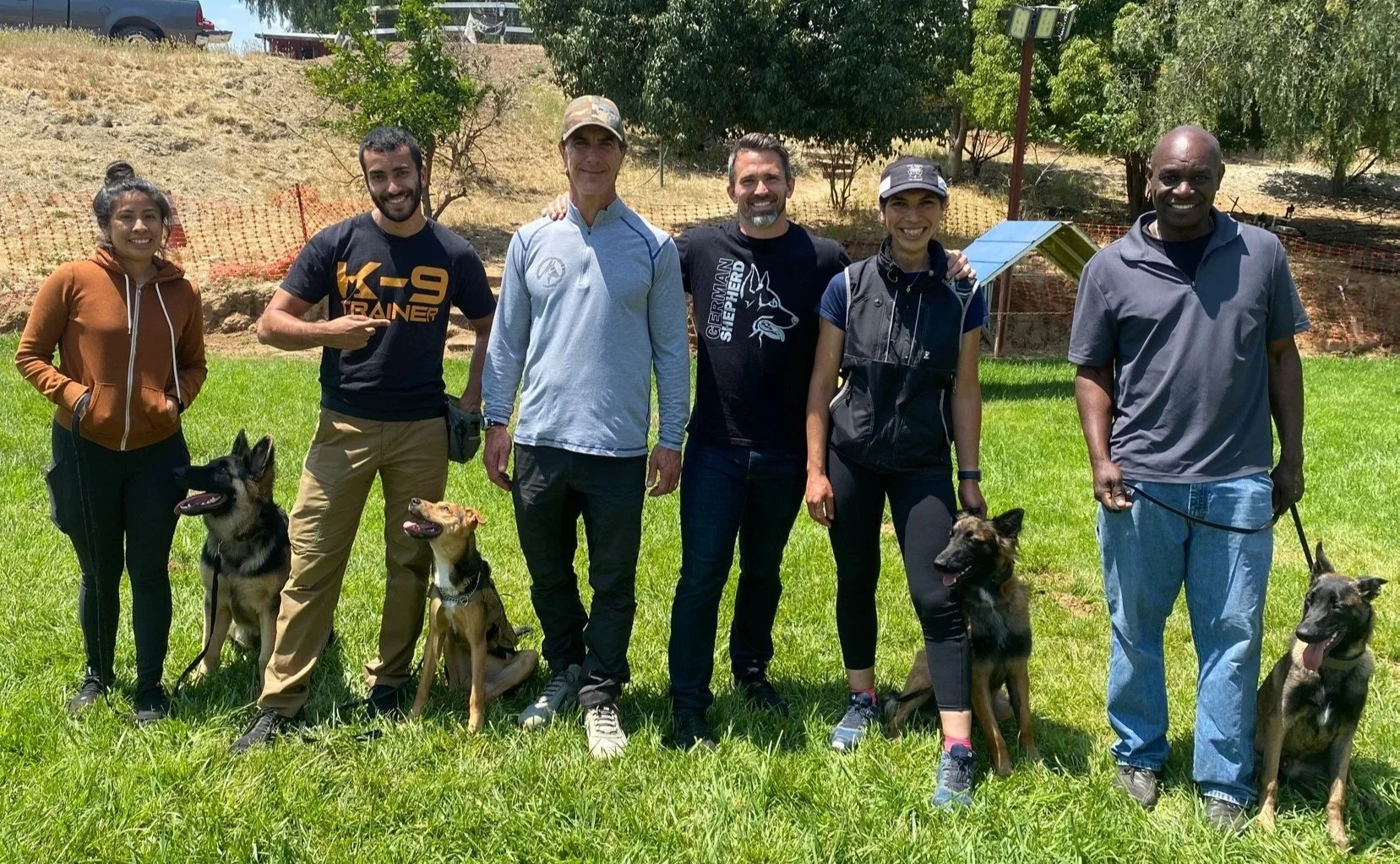 Nate Schoemer training alongside professional dog trainers during a workshop featuring guest trainer Robert Cabral.