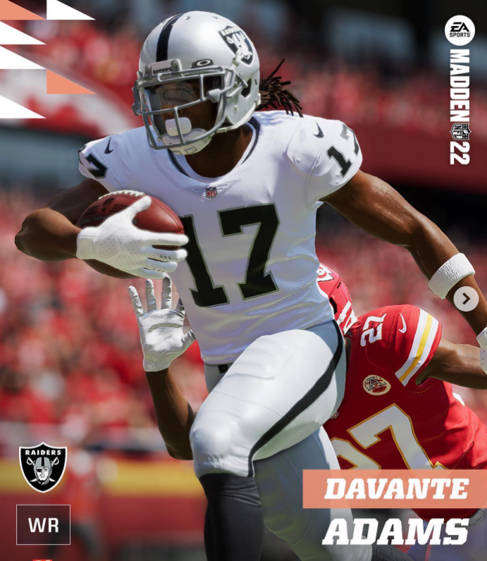 A football player wearing a white Raiders jersey with number 17, holding a football and running during a game, with a player from the opposing team in a red uniform nearby.