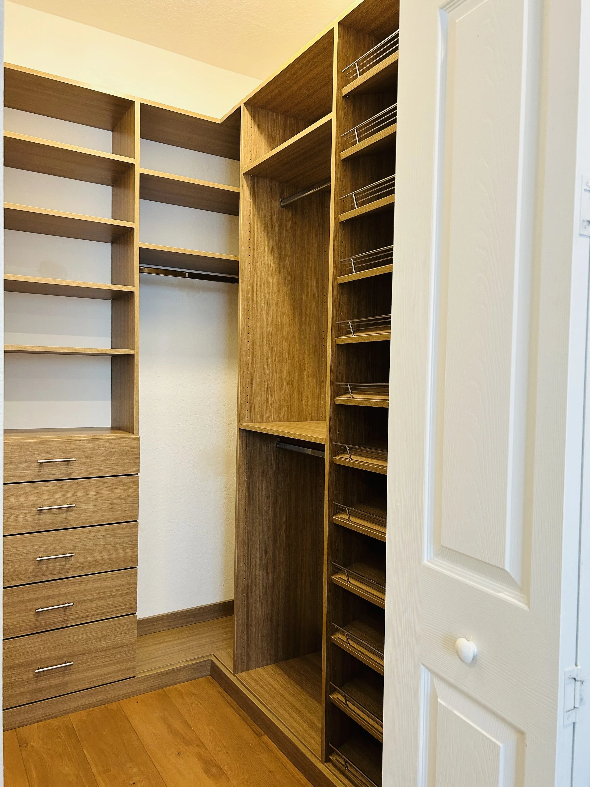 Custom L-shaped walk-in closet with shelving.