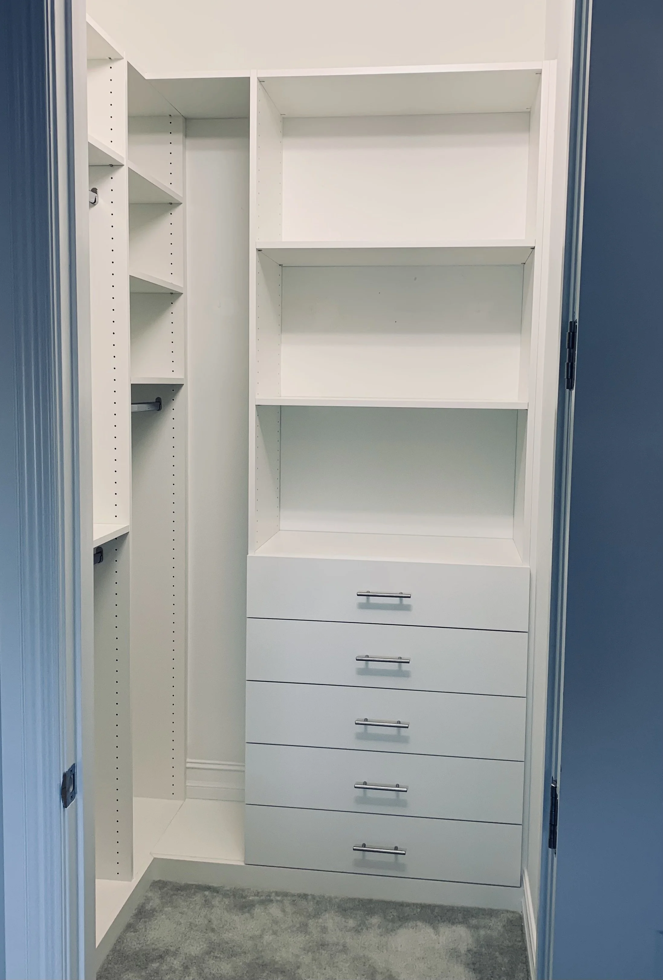 Daytona walk-in closet in White Melamine with custom shelving, drawers and hanging storage.