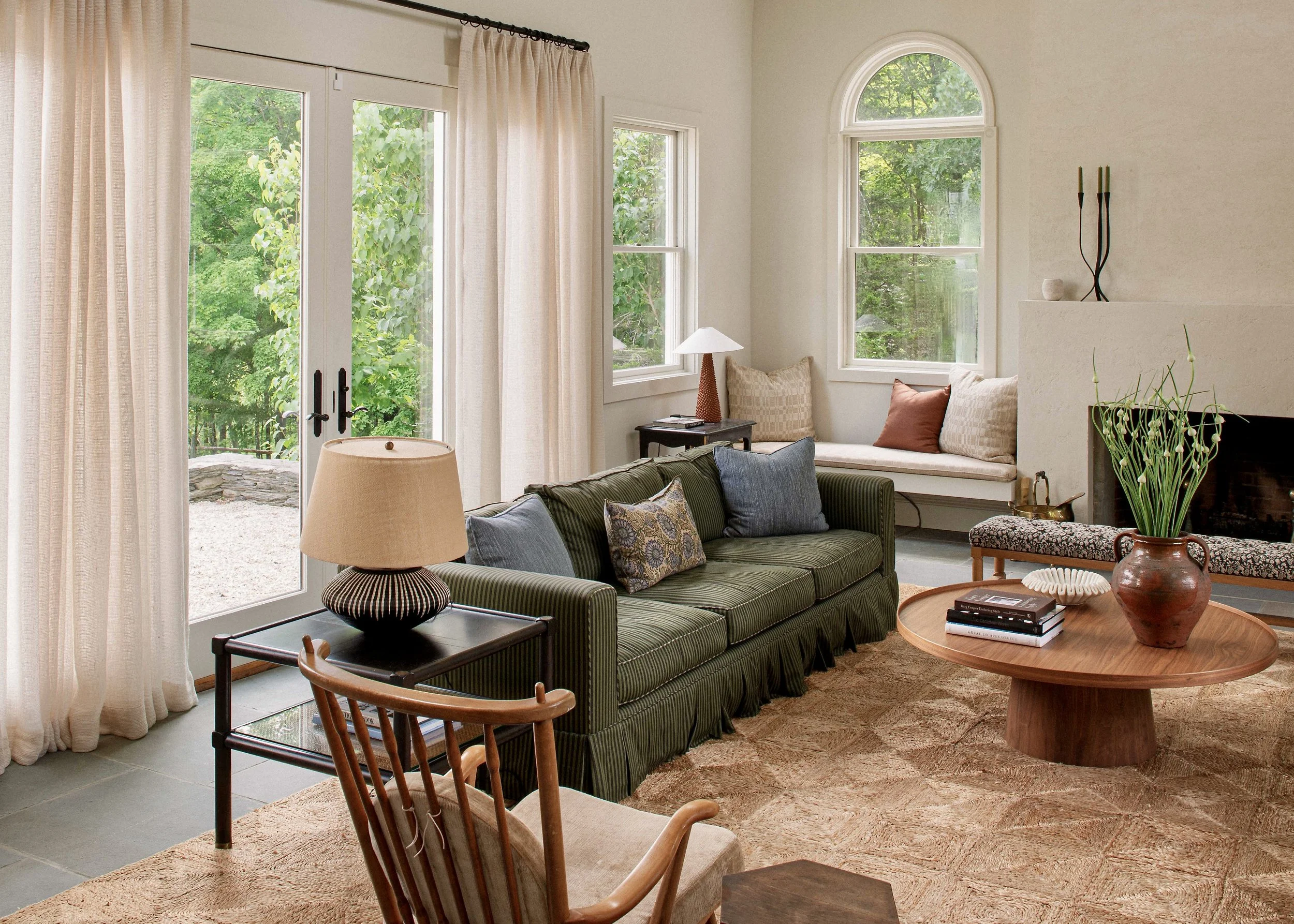Living room with a vaulted ceiling, deep green sofa and tall arched windows