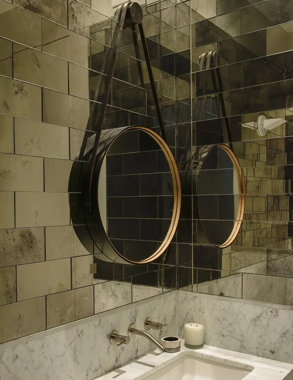 Bond St bathroom with round leather-strap mirrors on antiqued mirror tile walls